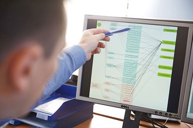 Ein BVL-Mitarbeiter deutet auf einen Bildschirm, auf dem verschiedene Warenströme abgebildet sind.